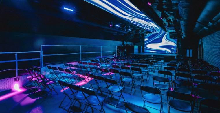 An arch laid out with rows of seating facing a large LED screen